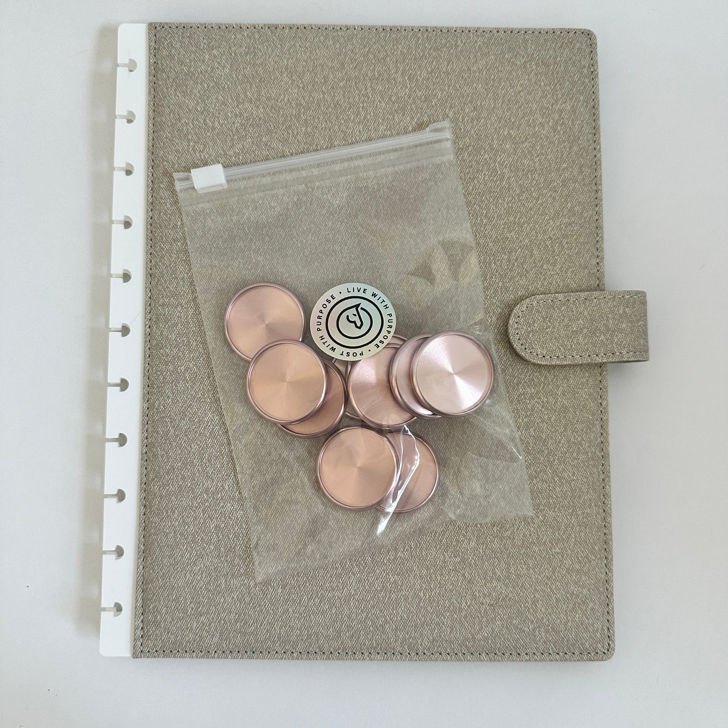 Gray pouch with pink buttons and a clear plastic bag on a white background