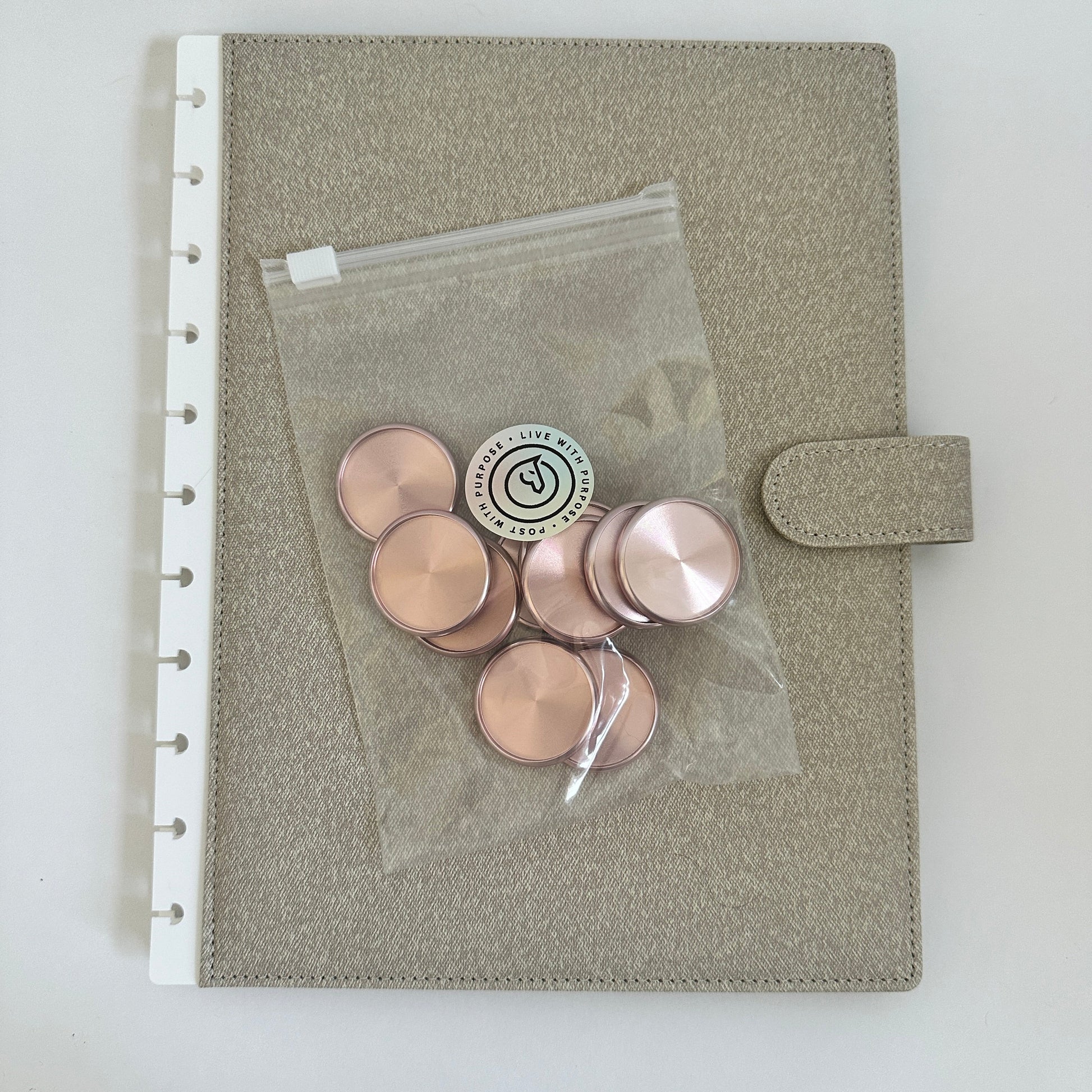 Gray pouch with pink buttons and a clear plastic bag on a white background